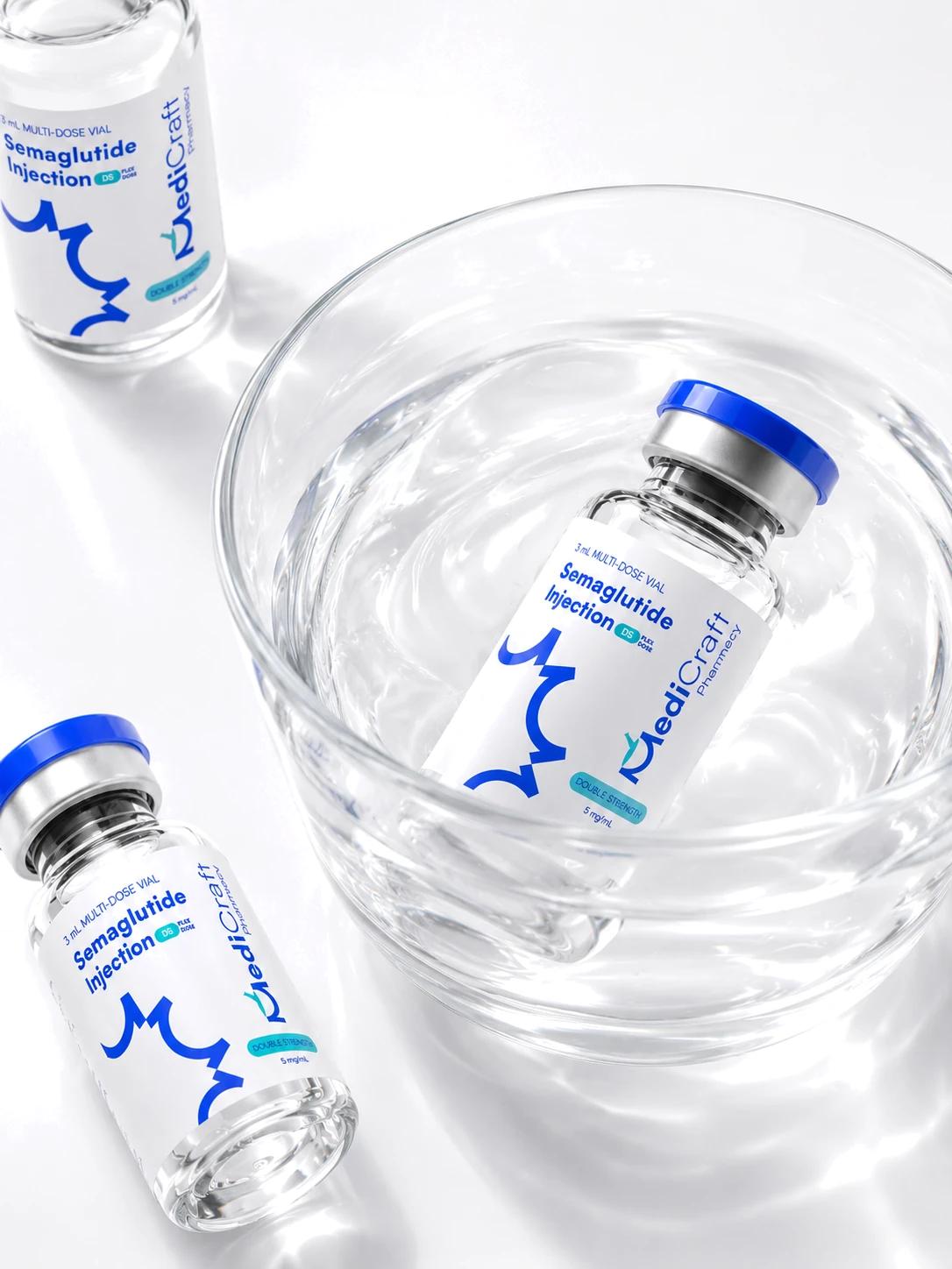 Two compounded preparation vials beside a glass of water