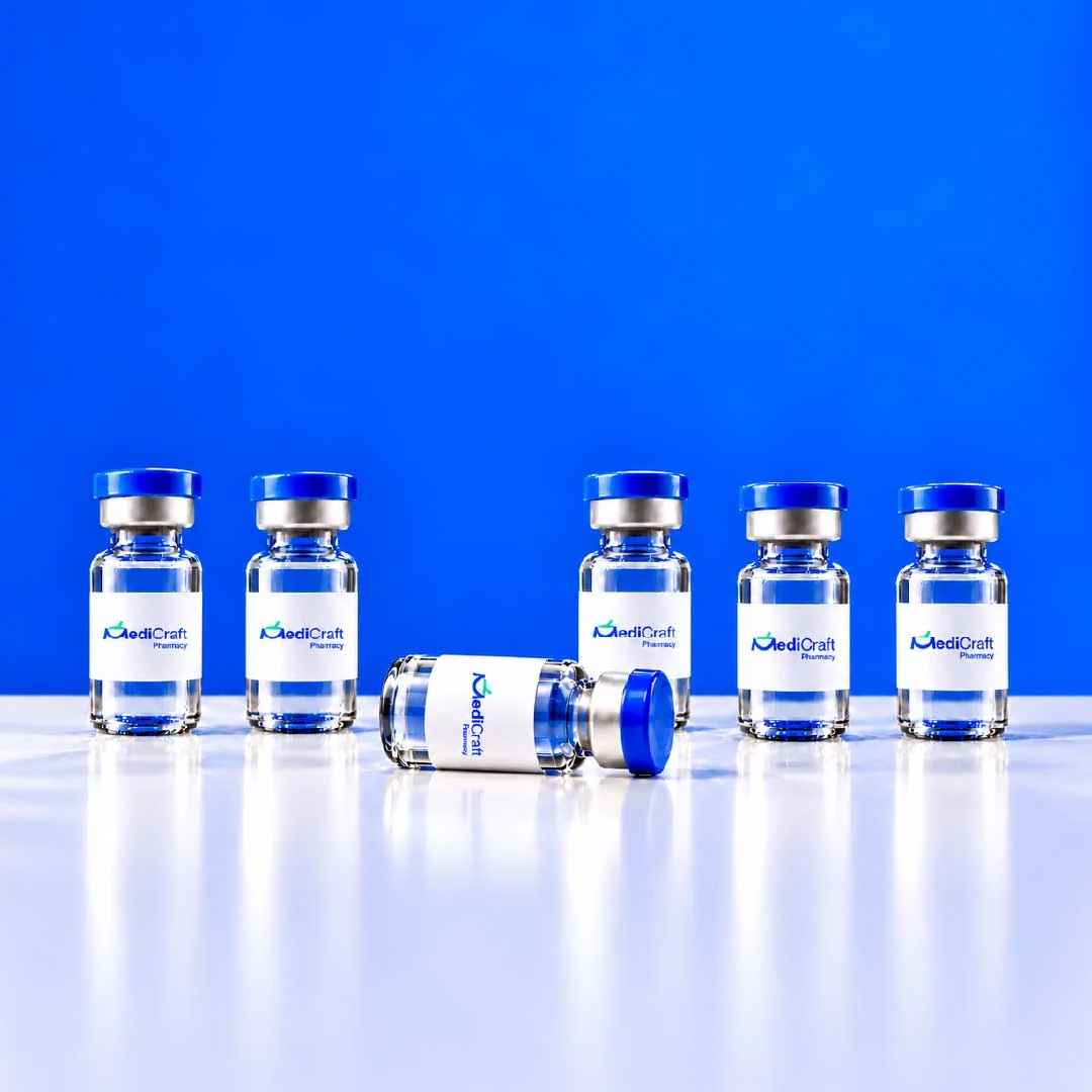 A row of blue-capped MediCraft vials, one lying on its side, on a white surface